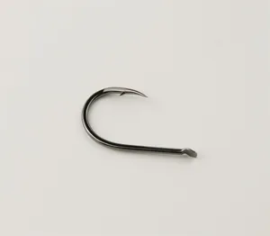 Close up detail of a sharp carbon steel offset fishing hook with barb in gunmetal.