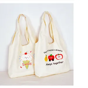 Close-up detail of beige canvas tote bag featuring cute cartoon fruit and ice cream prints.