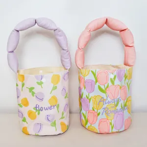 Tulip print bucket bag detail featuring puffy fabric handles and snap button closure.