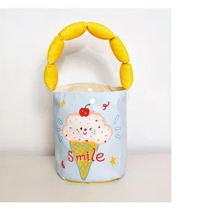 Canvas bucket bag detail shot featuring a unique yellow padded handle and cute ice cream graphic.