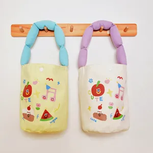 Detailed view of cute canvas bento bags featuring funny cartoon prints and soft chunky handles.