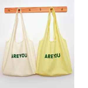 Canvas tote bag detail view, casual commuter shoulder bag with graphic print design, simple style.