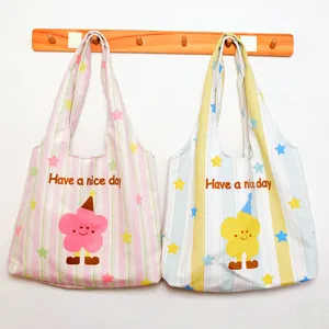 Canvas tote bag detail view, casual striped shoulder bag with cute flower graphic print.