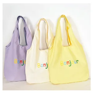 Vue détaillée de sacs cabas en toile décontractés en violet, beige et jaune avec imprimé.