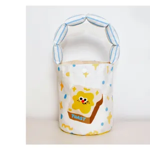 Canvas bucket bag detail featuring cute toast cartoon print and striped padded handle.