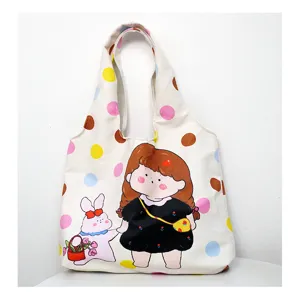 Close-up detail of casual canvas tote bag with cute cartoon girl and rabbit print pattern
