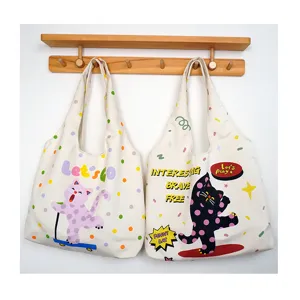 Detailed view of canvas tote bag featuring cute cat prints and stylish daily casual design.
