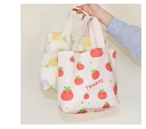 Close-up detail of cute canvas lunch tote bag with lovely tomato print and sturdy handles.