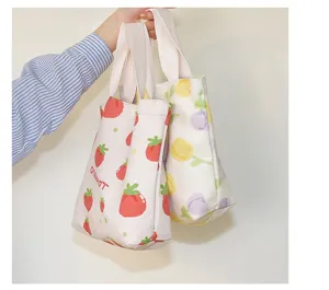 Detail view of canvas tote bags with cute strawberry and tulip prints, small lunch handbag.