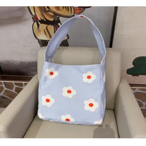 Light blue canvas shoulder bag with white and orange floral print for women daily commute.