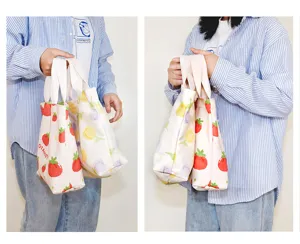 Detailed view of small canvas tote bag with cute strawberry and floral prints for daily use.