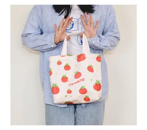 Detailed view of the cute tomato print canvas tote bag, small handbag with letter text.