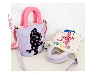 Canvas bucket bag with cute polka dot cat print, pink handles and crossbody strap.