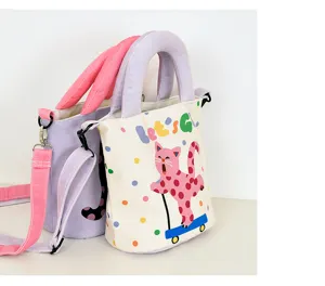 Detail view of the cute polka dot cat canvas bucket bag with handles and shoulder strap.