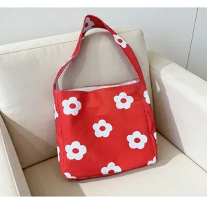 Red canvas shoulder bag with white flower print detail close up view, casual style