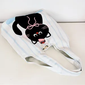 Detail view of canvas tote bag, blue white stripes and cute black cat print design.