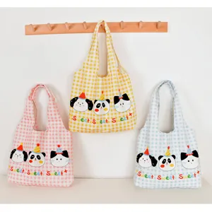 Detailed view of cute canvas tote bags featuring colorful plaid patterns and adorable animal prints.