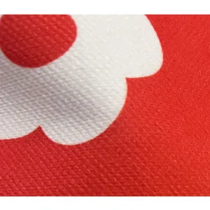 Detailed view of red and white floral printed fabric material, displaying clear vintage textile texture.