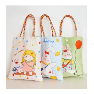 Close-up detail of cute cartoon printed canvas tote bag with colorful beaded handle.