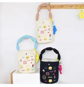 Detailed view of the cute canvas bucket bag featuring colorful embroidery, puff handle, and metal clasp.