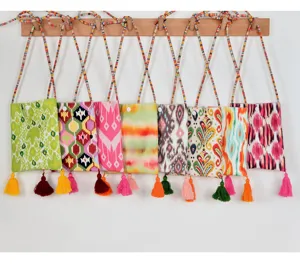 Ethnic style colorful print mini crossbody phone bag with tassel and woven strap details.