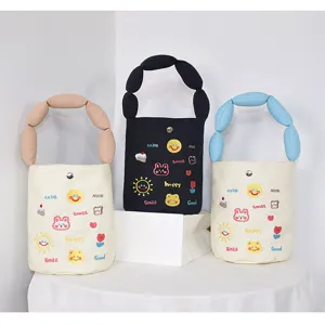 Canvas bucket bag with cute embroidered patches and padded handle, stylish handbag for daily use.
