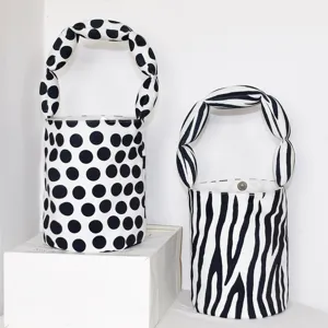 Canvas bucket handbag with twisted handle, black and white polka dot and zebra pattern design.