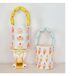 Cute canvas bucket bag detail showing bubble handle and sweet cake and ice cream cartoon print.