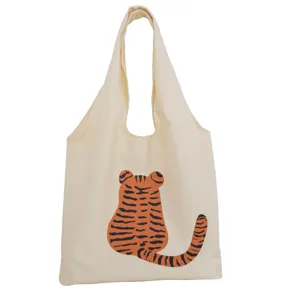 Beige canvas tote bag featuring a cute cartoon tiger back print, casual shoulder bag for use.