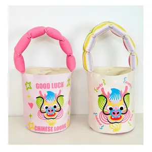 Cute Year of the Dragon canvas bucket bag with plush padded handle, cartoon dragon graphic detail.