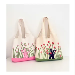 Closeup detail of cute polka-dot cat strawberry print canvas tote bag, spacious daily shoulder bag.