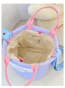 Detailed view of the purple quilted tote bag interior, showing storage pocket and stitching.