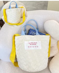 Quilted heart pattern canvas tote bag with blue handles and yellow shoulder strap for women