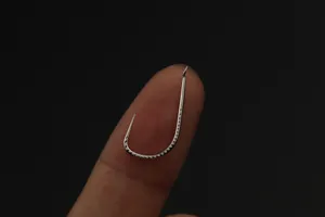 Gros plan détaillé de l'hameçon sans ardillon en acier au carbone avec texture d'écailles.