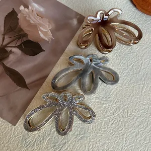 Set di mollette per capelli a fiore cavo in acetato, strass e raffinato design marmorizzato.