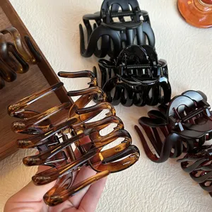 Detail shot of stylish tortoiseshell and black hair claw clips, elegant hair accessories.