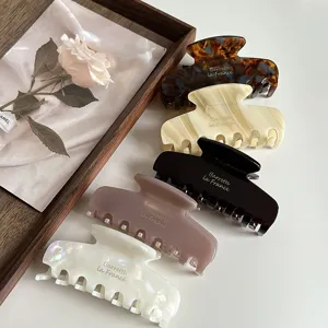 Elegant acetate hair claw detail showing assorted vintage colors and smooth polished surface texture.