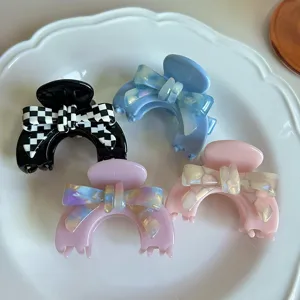 Primo piano dettagliato di mollette per capelli in acetato con grazioso fiocco bianco.