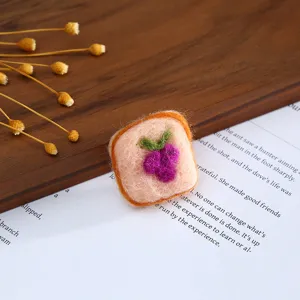 Close-up detail of the cute toast-shaped wool felt DIY handmade hair clip accessory.