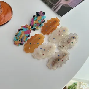 Detailed view of colorful rhinestone wavy hair clips, cute acrylic side hairpin accessories.