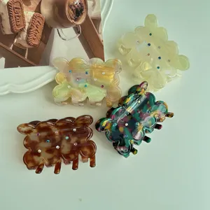 Cute acetate hair claw with colorful rhinestones and wave cookie design. Stylish hair accessory.