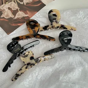 Detailed view of large acetate hair claw, elegant leopard and tortoise shell clip for women.