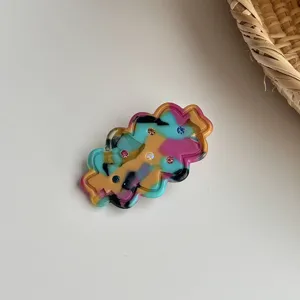 Close-up detail of the colorful rhinestone hair clip featuring sparkling crystals and vibrant design.