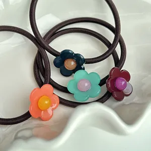 Vue détaillée de charmants élastiques à cheveux floraux avec de jolies breloques en résine.