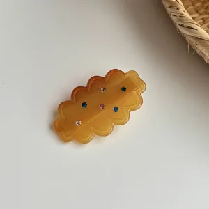 Detailed view of the stylish amber resin hair clip featuring colorful sparkling rhinestone embellishments.