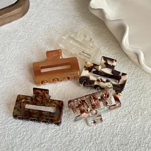 Detailed view of small acetate hair claw clips in tortoiseshell and solid colors.