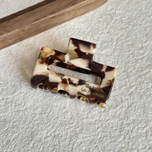 Detail shot of a small acetate hair claw clip with tortoise shell pattern. Perfect for bangs.