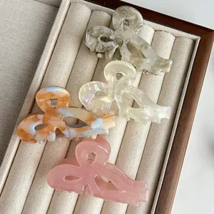 Sweet acetate bow hair claws for women, elegant hollow shark clips for daily styling and hair.