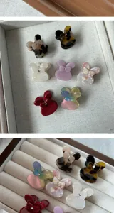 Detailed close-up of cute small acetate hair claws in various colors, elegant and stylish design.