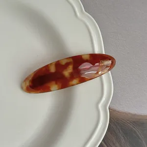 Detailed close-up shot of the vintage tortoise shell acetate oval hair clip texture.